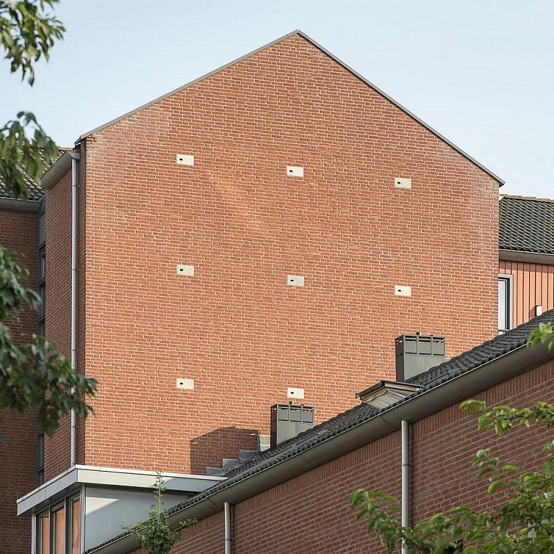 Inbouwstenen in zijkant huis